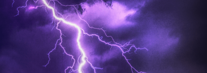 Photo of light purple lightning against dark purple clouds